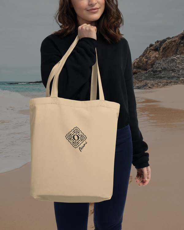 Recycled sustainable beige cotton tote bag, carried by a woman at the beach