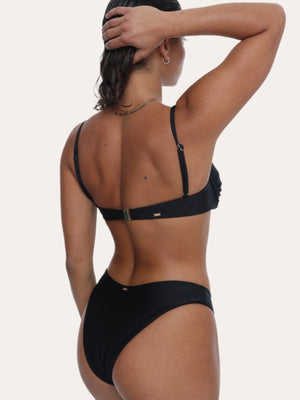  Amour black bikini Bottoms in Onyx with a gold ring, Sustainable recycled swimwear luxury bikini, seen on a model from the back raising one arm holding her hair