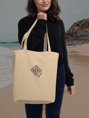 Recycled sustainable beige cotton tote bag, carried by a woman at the beach 