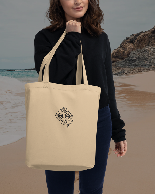 Recycled sustainable beige cotton tote bag, carried by a woman at the beach 