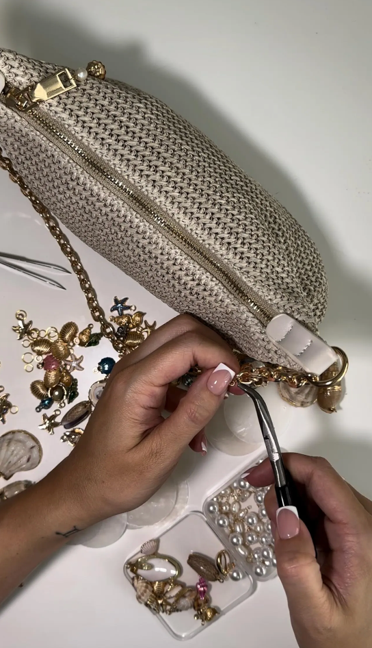 Handmade gold beige chain shell bag with pearls, seen being made on a table 